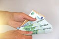 The man`s hand holds the 100 euro, considers them and pays. Pape Royalty Free Stock Photo