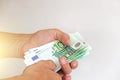The man`s hand holds the 100 euro, considers them and pays. Pape Royalty Free Stock Photo