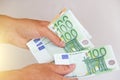 The man`s hand holds the 100 euro, considers them and pays. Pape Royalty Free Stock Photo