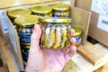 A man`s hand holds a glass jar of sprats i Royalty Free Stock Photo