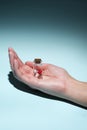 Man`s hand holds a glass transparent jar with pills on a light background close-up. medicines and vitamins. pharmaceuticals.