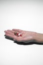 Man`s hand holds a glass transparent jar with pills on a light background close-up. medicines and vitamins. pharmaceuticals.