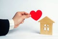 The man`s hand holds the heart and the house . House of lovers. Affordable housing for young families. Accommodation for lovers o Royalty Free Stock Photo