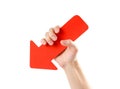 A man`s hand holds a large red arrow. Close up. Isolated on a wh Royalty Free Stock Photo