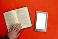 A man`s hand holds an open paper book on a red table Royalty Free Stock Photo