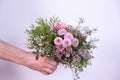 A man`s hand holds out a bouquet of festive flowers Royalty Free Stock Photo