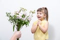 A man`s hand holds out a bouquet of white flowers to a cute little girl Royalty Free Stock Photo