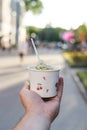 Man`s hand holds paper cup with ice cream Royalty Free Stock Photo