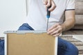 The man`s hand holds the screwdriver and screws the screw that secures the drawer guide. Royalty Free Stock Photo