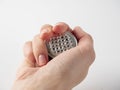 A man`s hand holds a used aluminum coffee capsule on a white background. Modern ways of storing coffee