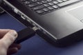 A man`s hand inserts a USB flash drive into a laptop usb Royalty Free Stock Photo