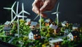 Man\'s hand installing wind Turbine on Miniature eco-city plan presentation with small houses, streets Royalty Free Stock Photo