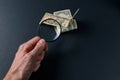 Man`s hand with magnifying glass and money on black background. Paper currency Royalty Free Stock Photo