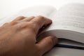 Man`s hand on an open book with white pages Royalty Free Stock Photo