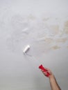 Man`s hand painting stains on the ceiling