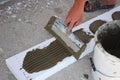 Man's Hand Plastering a Wall Styrofoam or Foam Board Insulation with Trowel. Styrofoam Insulation for Basement Walls.