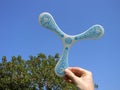 Man`s hand with plastic boomerang read to flight on a blue sky Royalty Free Stock Photo