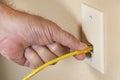 man& x27;s hand plugging yellow ethernet cable RJ45 into home network socket Royalty Free Stock Photo