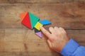 Man's hand pointing at rocket made from square tangram puzzle Royalty Free Stock Photo