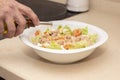 A man`s hand pouring olive oil on top of a mixed salad. Royalty Free Stock Photo