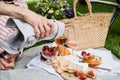 Man`s hand pouring rose wine into glasses, summer picnic