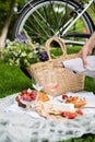 Man`s hand pouring rose wine into glasses, summer picnic