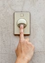 Man's hand pressing a doorbell