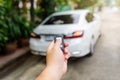 A man`s hand is pressing the remote to lock or unlock the car door Royalty Free Stock Photo