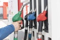 Man`s hand pulling up handle of one of four gas pumps on gasoline station Royalty Free Stock Photo