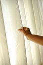 Man's hand pulling a window curtain Royalty Free Stock Photo
