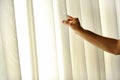 Man's hand pulling a window curtain Royalty Free Stock Photo