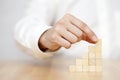 Man`s hand put wooden blocks in the shape of a staircase Royalty Free Stock Photo