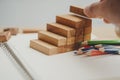 Man`s hand put wooden blocks in the shape of a staircase. Royalty Free Stock Photo