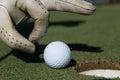 Man`s hand putting golf ball in hole Royalty Free Stock Photo