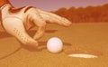 Man`s hand putting golf ball in hole Royalty Free Stock Photo