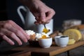 Man`s hand putting jam from bowl on bread with ricotta cheese