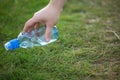 Man`s hand raises plastic bottle. garbage collection in nature in forest. collection of recyclable waste