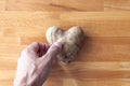 A man`s hand reaches down to pick up a heart shaped potato laying on a wooden cutting board  making a great background symbolizin Royalty Free Stock Photo