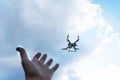 The man`s hand reaches for the flying drone. Drone in focus