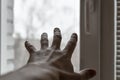 Man`s hand reaches for window. Concept: asking for help, depression, finding way out, freedom, sharing your feelings. Hand