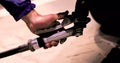 Man's hand refuels a car at a gas station with a gas pistol.