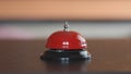 A man`s hand rings the bell at the front desk, close-up, blurred neutral background, selective focus. Concept: Call the receptioni