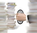 Man`s hand seizing clock to cause deformation with stacks books