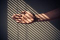 Man's hand with shadows from blinds