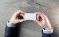 Man`s hand showing business card - closeup shot on dark wooden background Royalty Free Stock Photo