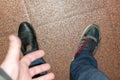 Man`s hand shows on feet in different shoes