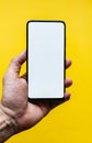 The man`s hand shows a smartphone with a white screen in an upright position