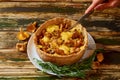 Man`s hand sliced homemade chanterelle mushrooms and cheese pie quiche - traditional swedish pie Royalty Free Stock Photo