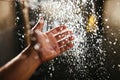 A man`s hand in a spray of water in the sunlight against a dark background. Water as a symbol of purity and life Royalty Free Stock Photo