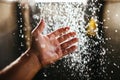 A man`s hand in a spray of water in the sunlight against a dark background. Water as a symbol of purity and life Royalty Free Stock Photo